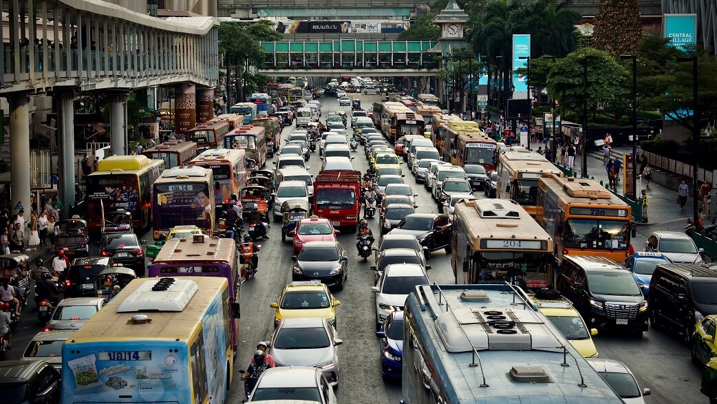 Engarrafamento de carros e ônibus em uma avenida larga