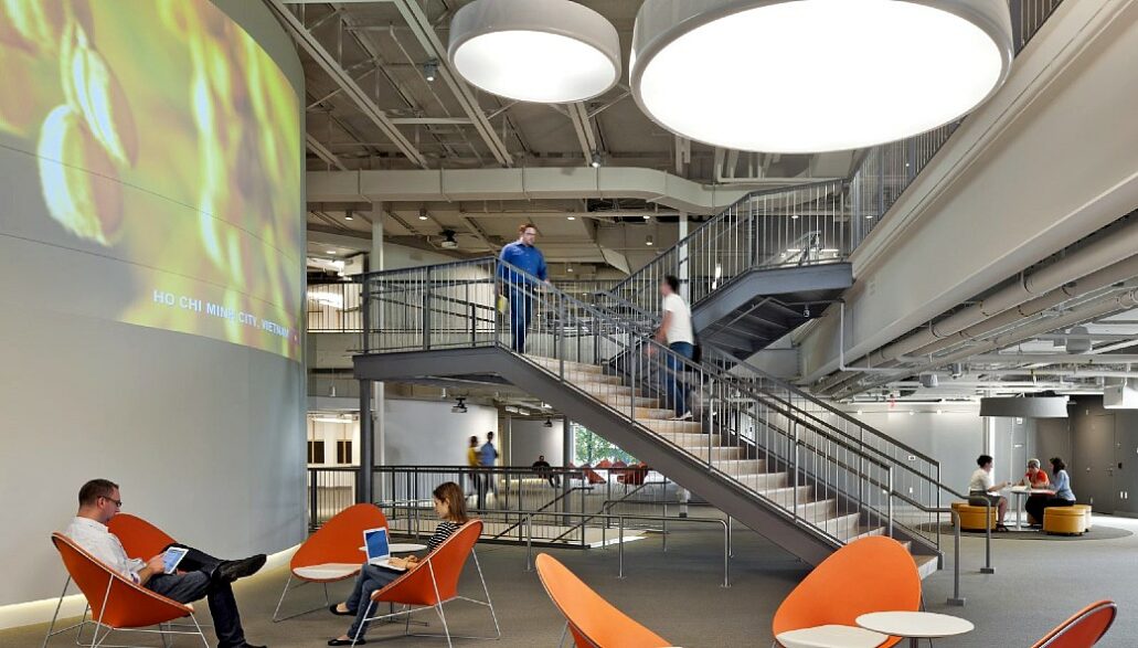 laboratório de inovação de Harvard com pessoas circulando pelas escadas de concreto e pesquisadores sentados em mesas