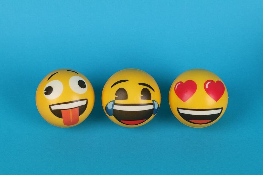 bolas pintadas como emojis sobre fundo azul