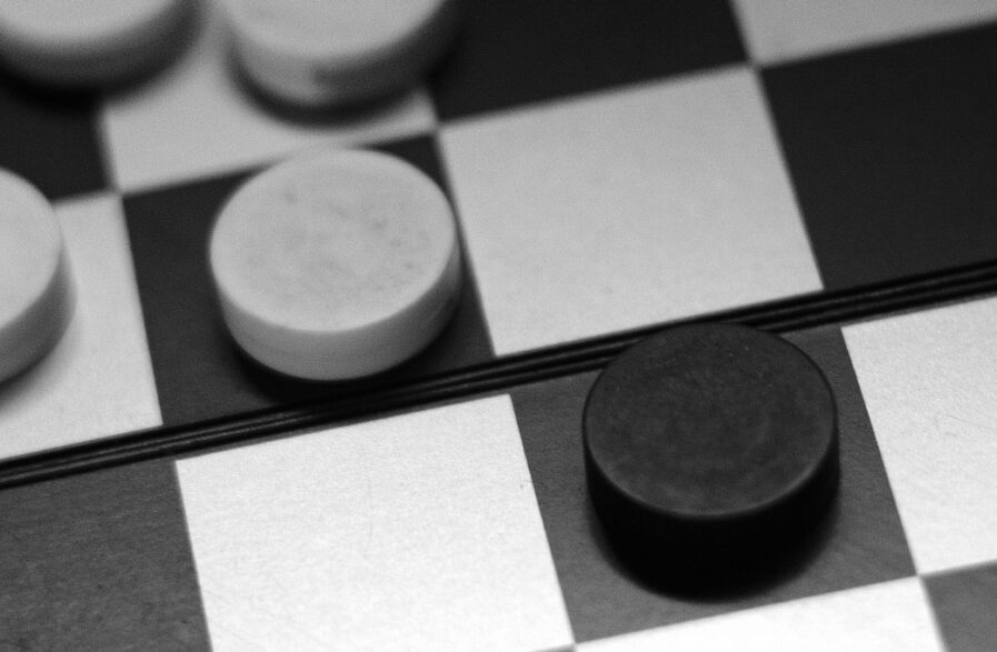 tabuleiro de jogo de damas com peças em preto e branco