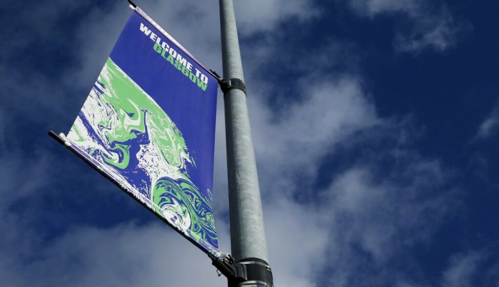 cartaz da conferência do clima COP26 é visto preso a um poste em Glasgow, na Escócia
