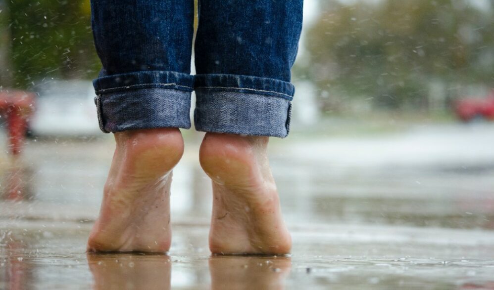 pessoa na ponta dos pés com chão molhado
