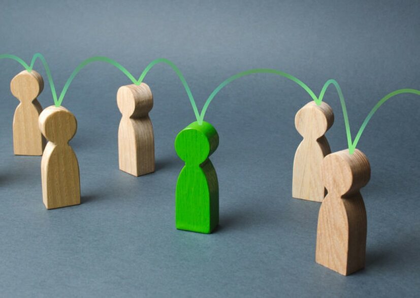 bonecos de madeira interligados por um boneco verde