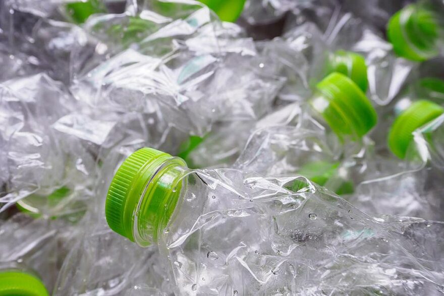 garrafas de plastico transparente com tampa verde enchem um conteiner