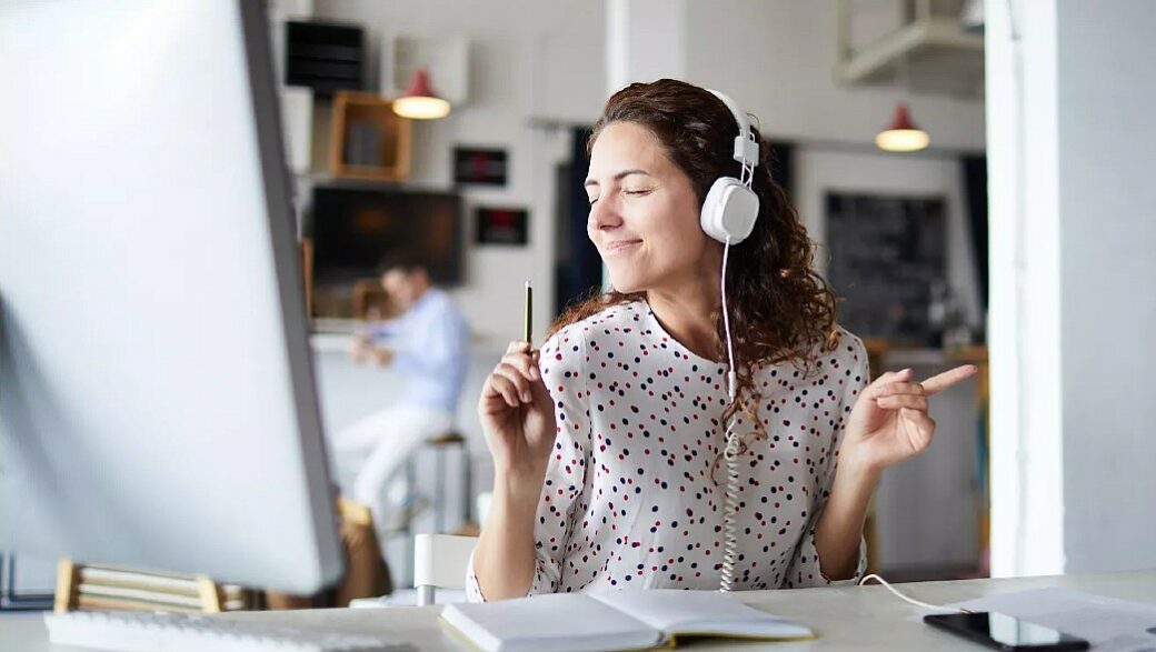 mulher jovem ouve música durante um momento do trabalho