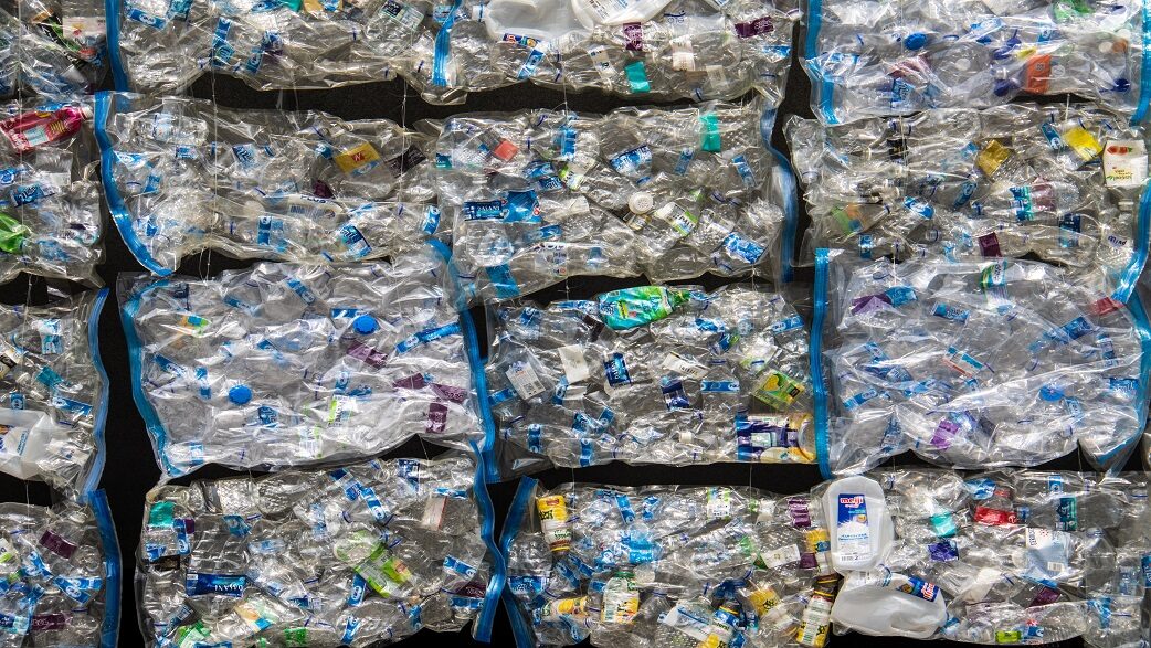 Imagem mostra garrafas plásticas compactadas em embalagens transparentes para serem recicladas