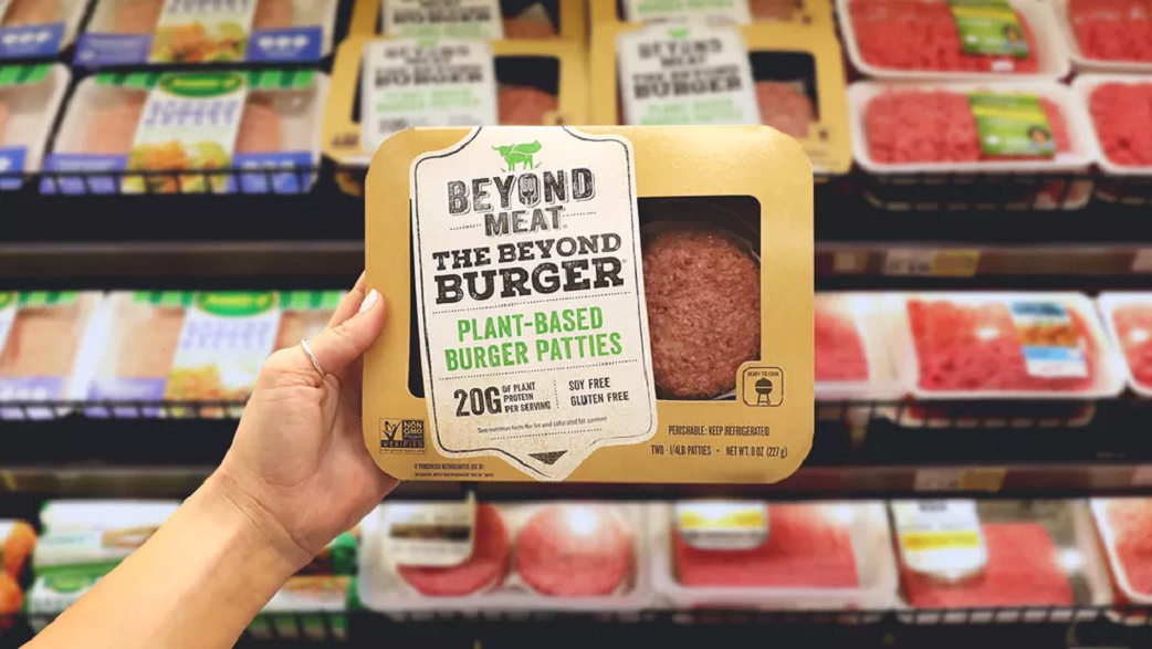 Imagem mostra uma mão segurando a embalagem do hambúrguer plant-based da Beyond Meat