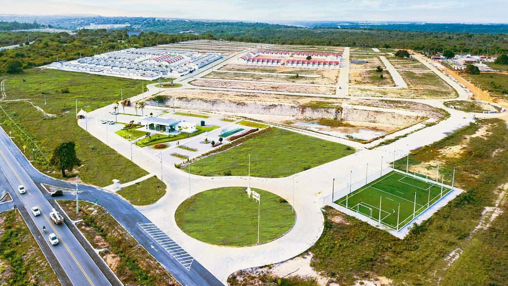 Foto aérea mostra a área da smart city em Natal, com lotes, uma quadra e espaços verdes.